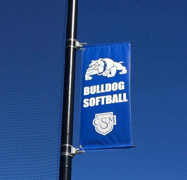 Custom outdoor banner for Bulldog softball team, attached to a pole in a sporting venue.