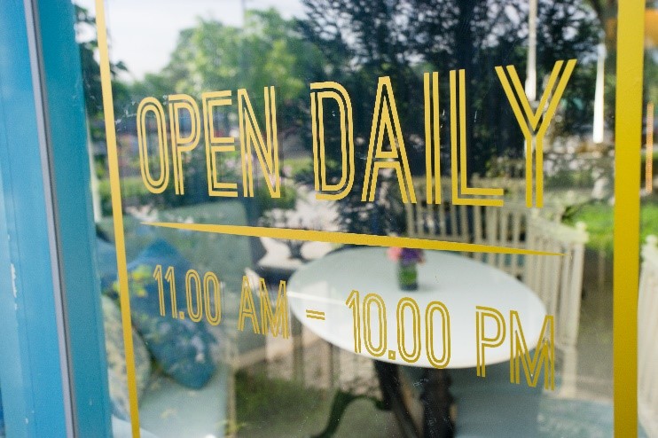 Vinyl lettering on window displaying hours. 