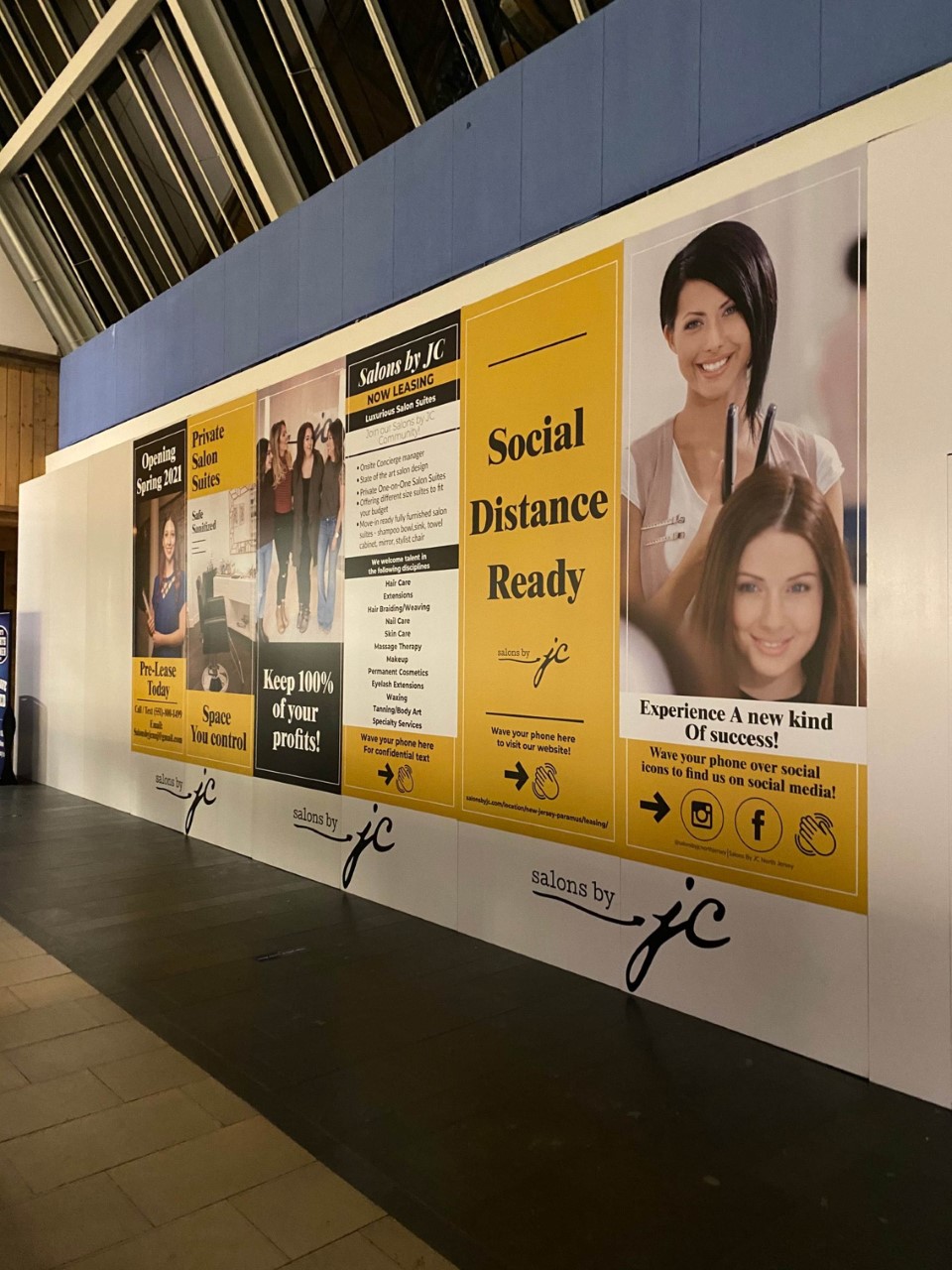 Colorful advertising banner and poster displayed on a wall.